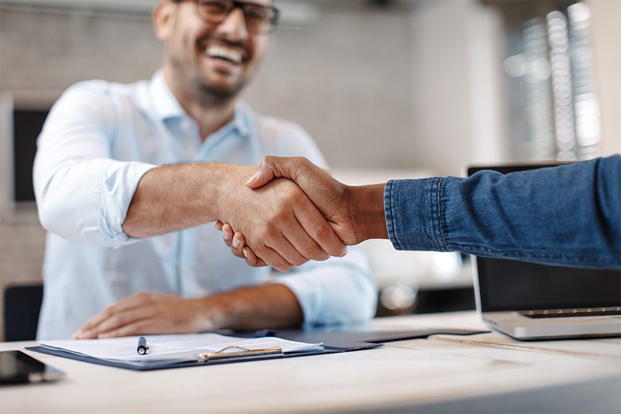 About Our Agency - Close up of a Handshake between Business Colleagues in the Office with a Focus on the Handshake and the Colleague and Background Blurred